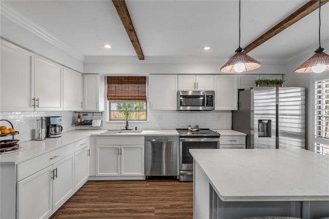 kitchen with stainless steel appliances, white cabinetry, beamed ceiling, and decorative light fixtures