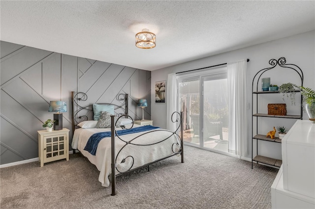 carpeted bedroom with access to exterior and a textured ceiling