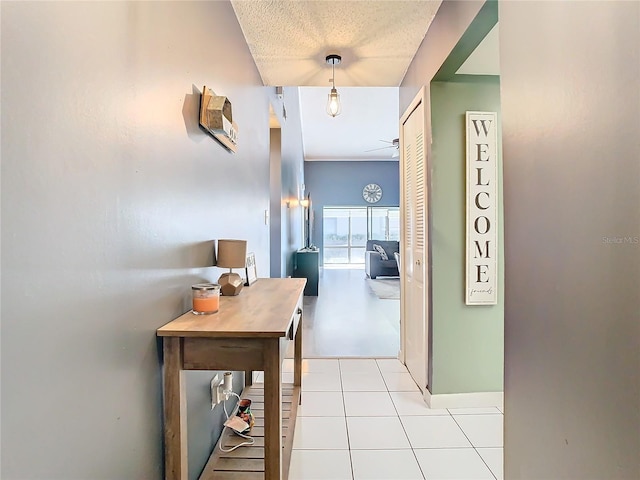 hallway with light tile patterned floors and a textured ceiling