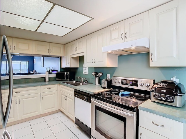 kitchen featuring light tile patterned floors, appliances with stainless steel finishes, sink, and white cabinets