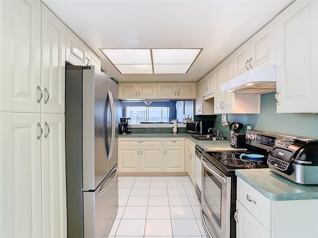 kitchen featuring white cabinetry, stainless steel appliances, sink, and light tile patterned floors