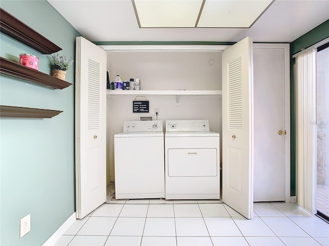 clothes washing area featuring light tile patterned floors and washing machine and clothes dryer