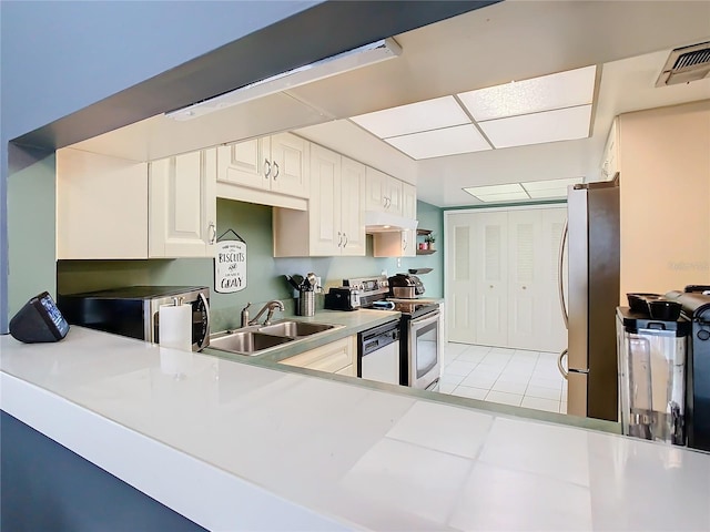 kitchen with white cabinetry, stainless steel appliances, sink, and light tile patterned floors