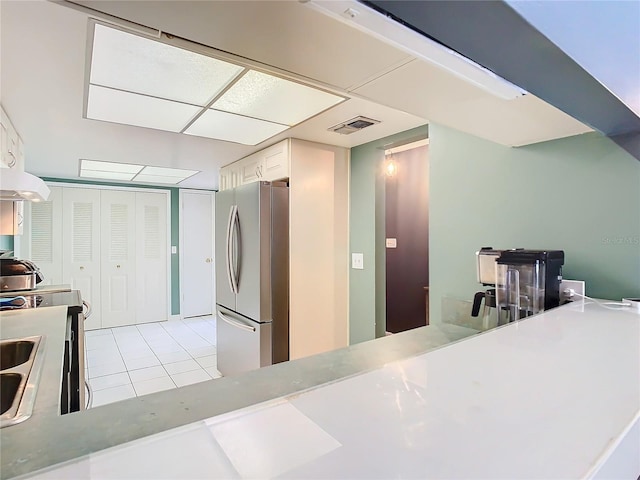 kitchen with white cabinetry, stainless steel appliances, and light tile patterned floors