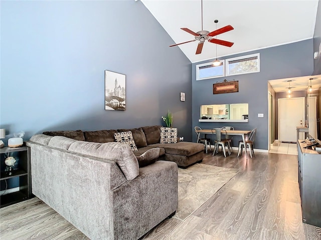 living room with ceiling fan, hardwood / wood-style floors, and high vaulted ceiling