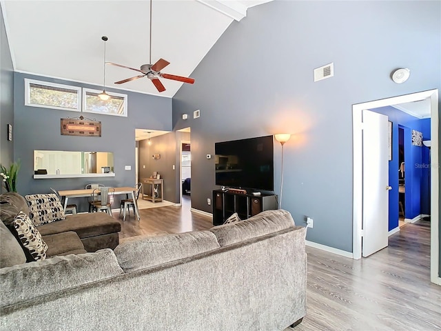 living room with hardwood / wood-style flooring, ceiling fan, high vaulted ceiling, and beamed ceiling