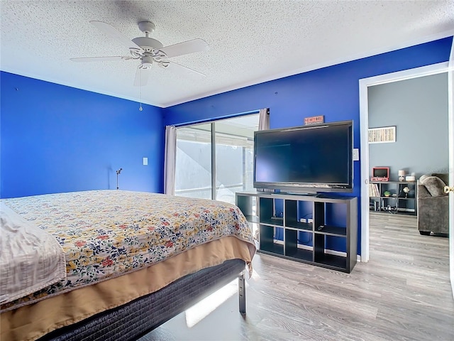 bedroom with ceiling fan, a textured ceiling, and light hardwood / wood-style flooring