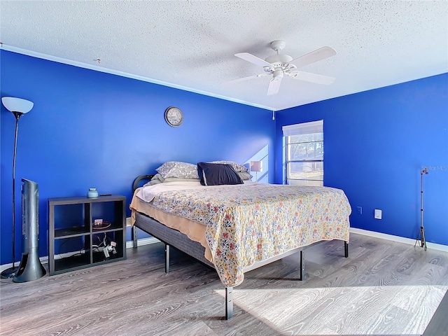 bedroom featuring hardwood / wood-style flooring, ceiling fan, and a textured ceiling