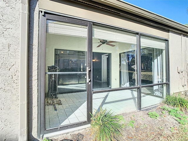 property entrance with ceiling fan