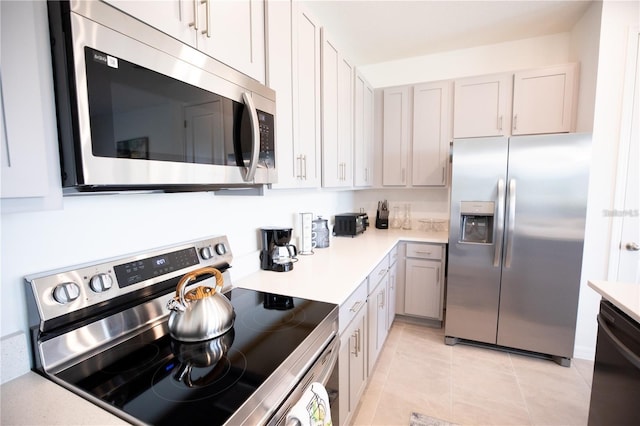 kitchen with gray cabinets, light tile patterned flooring, and appliances with stainless steel finishes