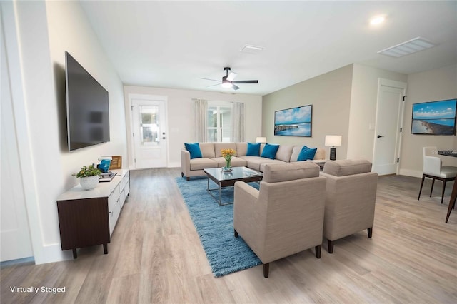 living room featuring light hardwood / wood-style flooring and ceiling fan