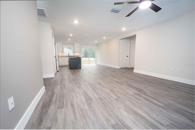 unfurnished living room featuring wood-type flooring and ceiling fan