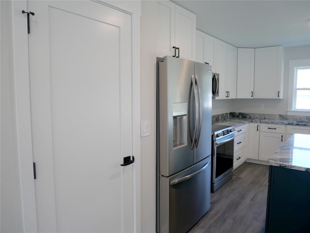 kitchen featuring white cabinetry, stainless steel appliances, dark hardwood / wood-style floors, and light stone counters