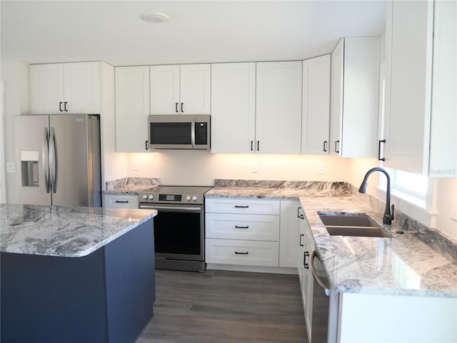 kitchen with appliances with stainless steel finishes, sink, and white cabinets