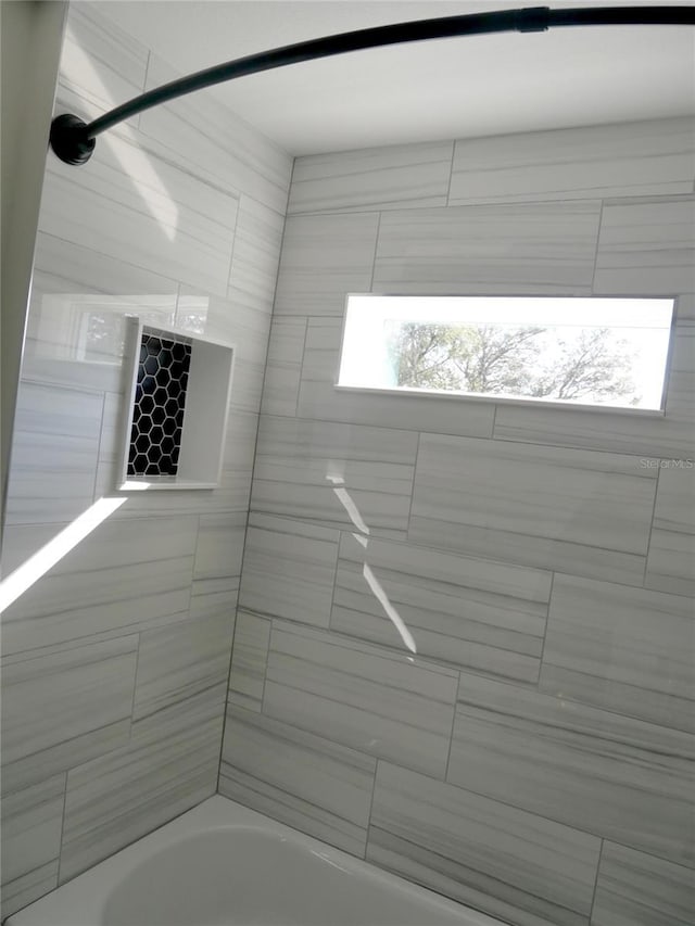 bathroom featuring tiled shower / bath