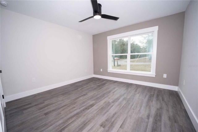 spare room with dark hardwood / wood-style floors and ceiling fan