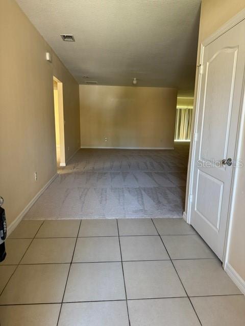 tiled spare room featuring a textured ceiling