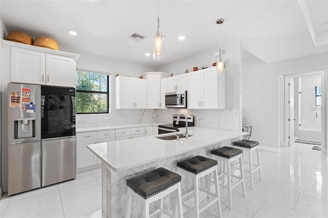 kitchen featuring stainless steel appliances, hanging light fixtures, a breakfast bar area, and kitchen peninsula