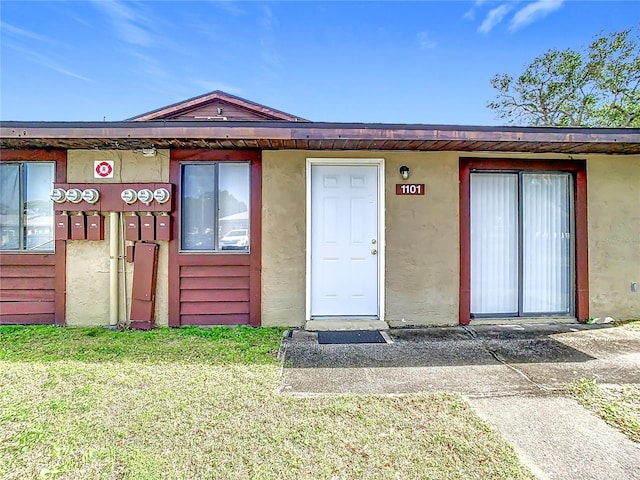 view of exterior entry with a lawn