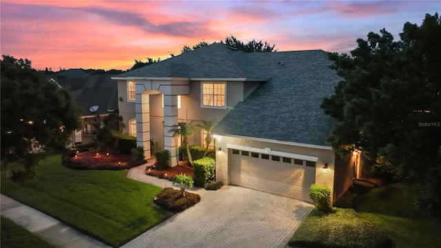 view of front of property with a garage and a lawn