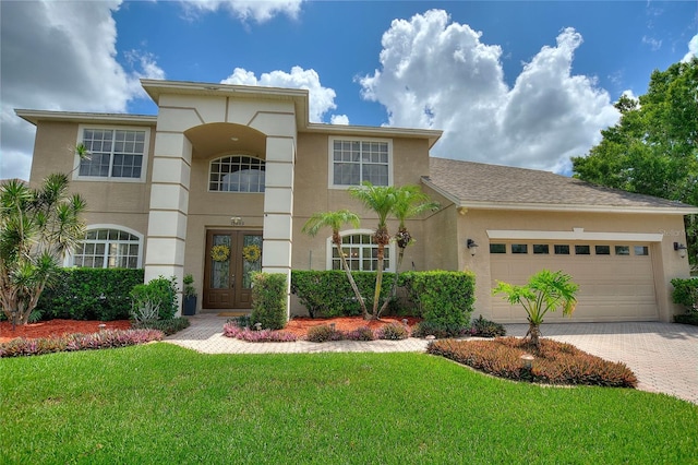 view of front of house featuring a garage, a front lawn, and french doors