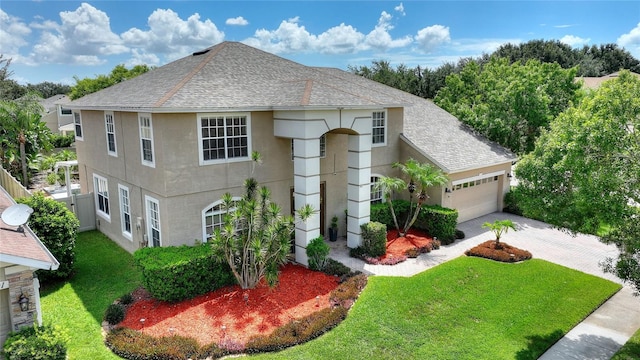 view of property with a garage and a front lawn