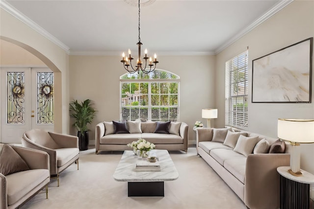 carpeted living room featuring french doors, ornamental molding, and a notable chandelier