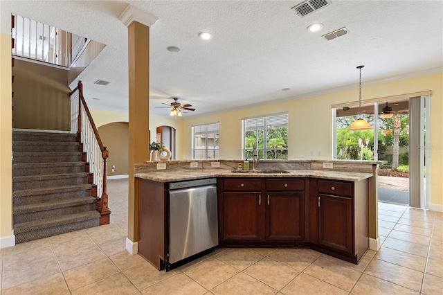 kitchen featuring dishwasher, sink, hanging light fixtures, light tile patterned floors, and light stone counters