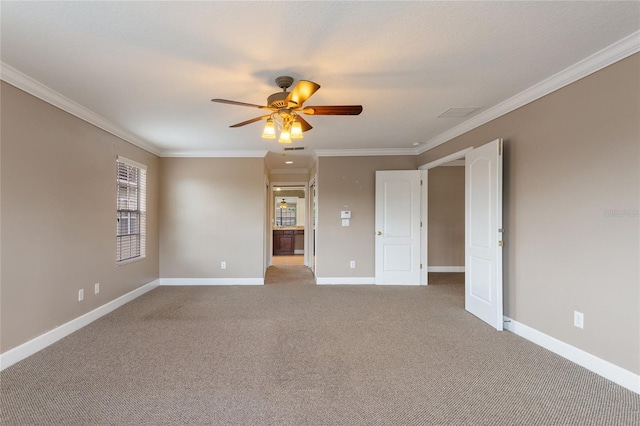 carpeted spare room featuring crown molding and ceiling fan