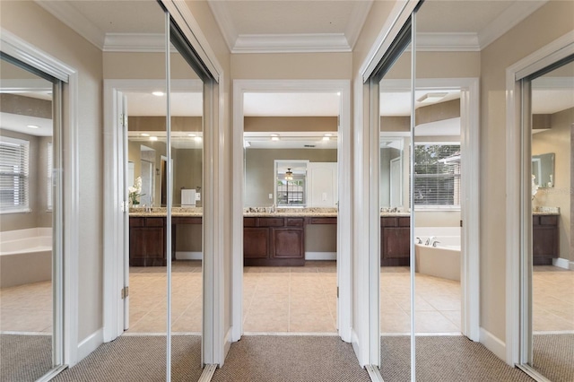 corridor with crown molding and light colored carpet