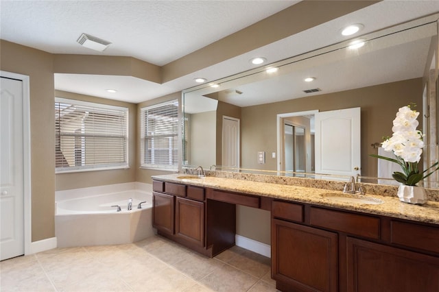 bathroom featuring vanity, tile patterned floors, and a tub