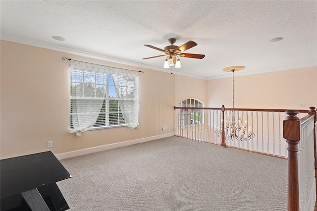 carpeted spare room featuring ornamental molding, ceiling fan with notable chandelier, and a textured ceiling