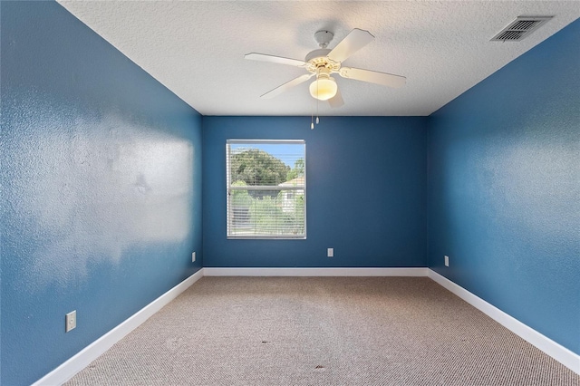 carpeted empty room with ceiling fan and a textured ceiling