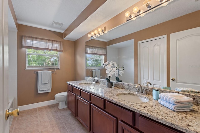 bathroom featuring vanity, tile patterned floors, and toilet