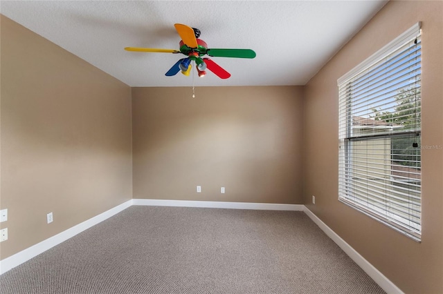 carpeted empty room featuring ceiling fan and a textured ceiling