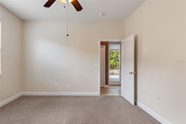 carpeted spare room with ceiling fan and a textured ceiling