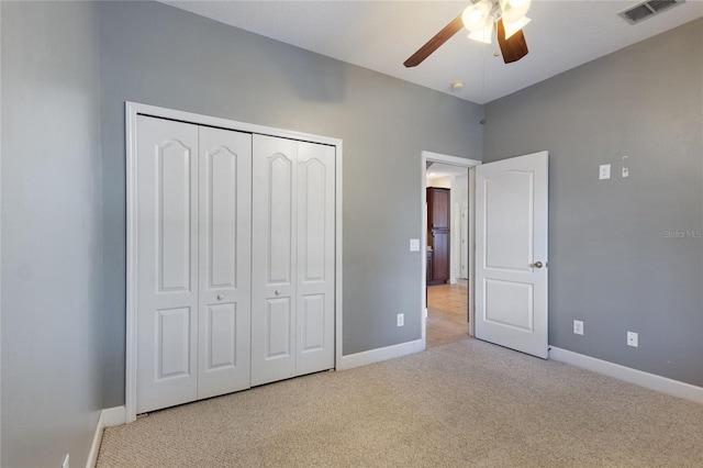 unfurnished bedroom featuring light carpet, ceiling fan, and a closet