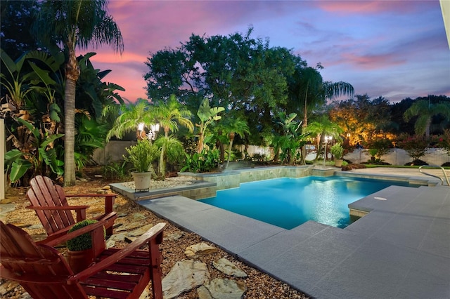 pool at dusk with a patio area