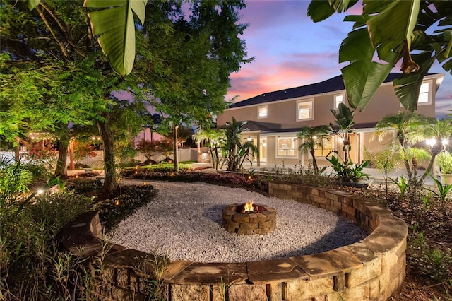 yard at dusk featuring a fire pit