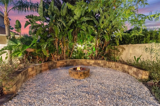 yard at dusk featuring an outdoor fire pit