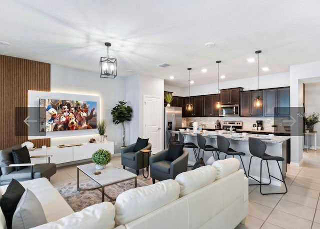 living room with light tile patterned floors, a notable chandelier, and sink