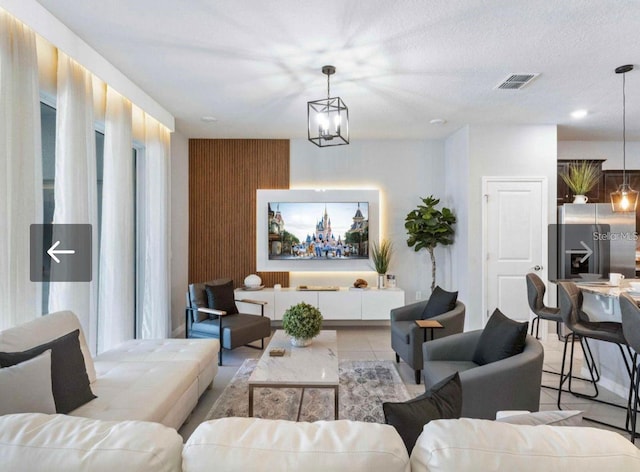 living room featuring light tile patterned floors and a notable chandelier