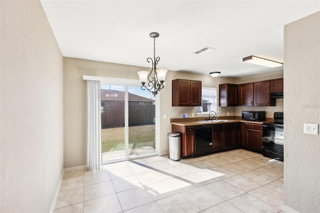 kitchen featuring sink, decorative light fixtures, black appliances, and light tile patterned floors