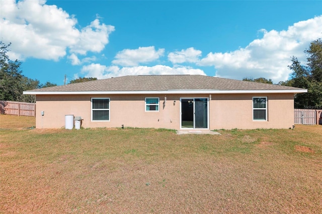 rear view of property featuring a yard