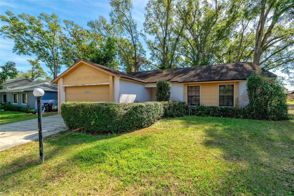 single story home featuring a garage and a front yard