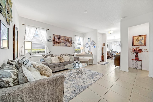 tiled living room featuring a chandelier and a textured ceiling