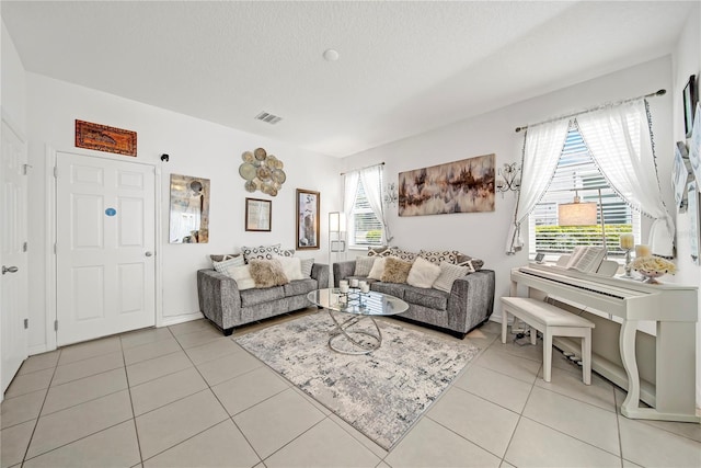 tiled living room featuring a textured ceiling