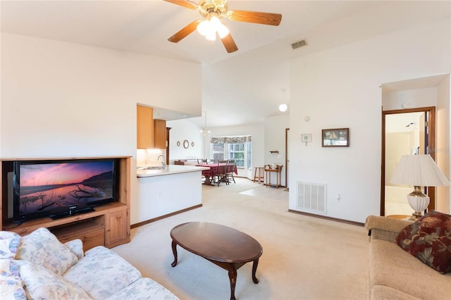 living room featuring ceiling fan with notable chandelier, sink, light carpet, and high vaulted ceiling