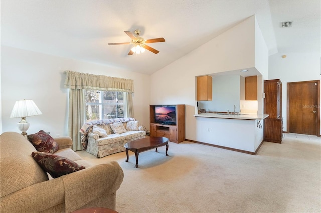 carpeted living room with ceiling fan, high vaulted ceiling, and sink