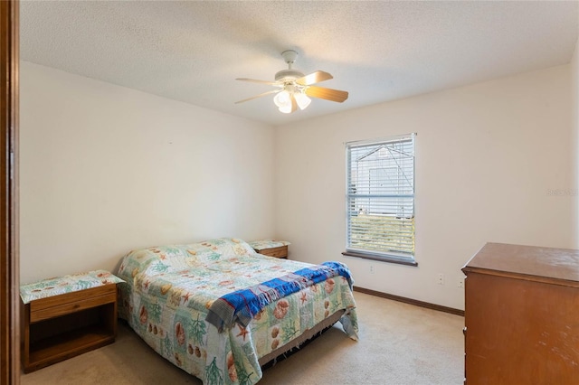 carpeted bedroom with ceiling fan and a textured ceiling